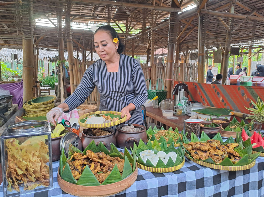 Penjual di Pasar Pundensari Menggunakan Pakaian Daerah sedang melayani pembeli. Foto: Dok. Nia/RRIMadiun