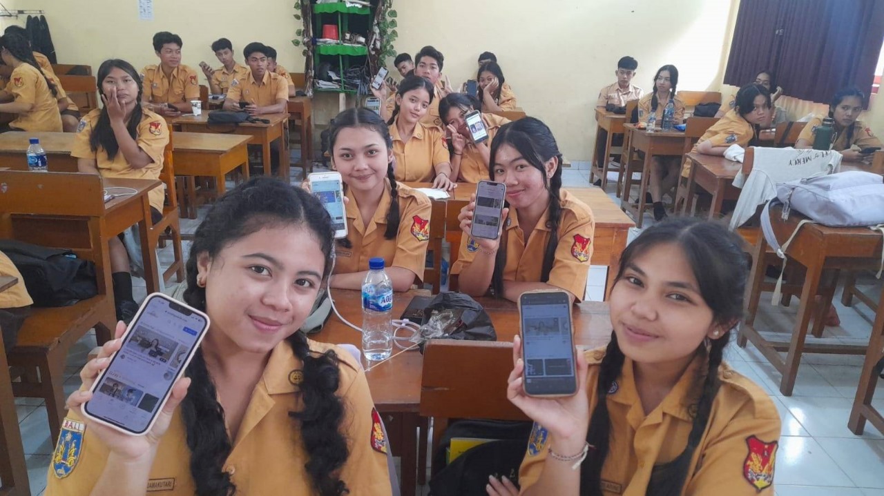 Para siswa sedang mendownload aplikasi Gan Jing World di sekolah (sumber: istimewa)