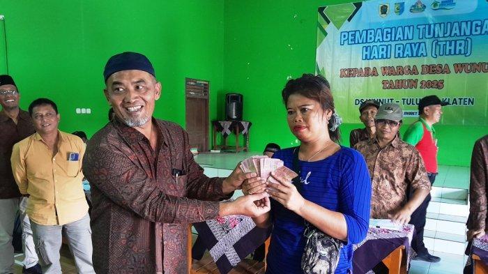 Kepala Desa Wunut Iwan Sulistiya Setiawan menyerahkan THR untuk warga Desa. Foto : jogja.tribunews.com