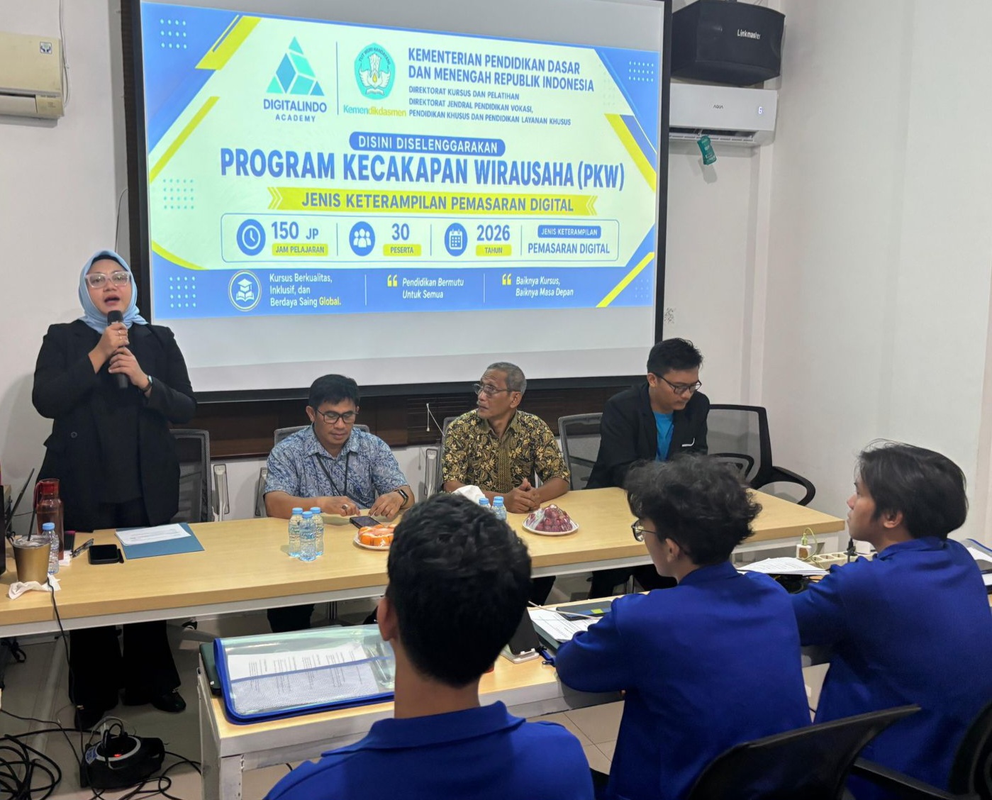 Direktur LKP Digitalindo Academy, Yunita, S.E. (kiri), memberikan sambutan saat pembukaan Program Kecakapan Wirausaha (PKW) bidang Pemasaran Digital di Kota Depok, Jawa Barat. Acara yang didukung Kemendikdasmen RI ini turut dihadiri Kasi PAUD Dikmas Disdik Depok Abdul Manan, S.E. (kedua kiri) dan perwakilan Kecamatan Cilodong Rasiman, S.Pd. (kedua kanan) guna membekali Anak Usia Sekolah Tidak Sekolah (ATS) keterampilan digital, Jumat (22/5/2026). (Foto: Dok. Digitalindo Academy)