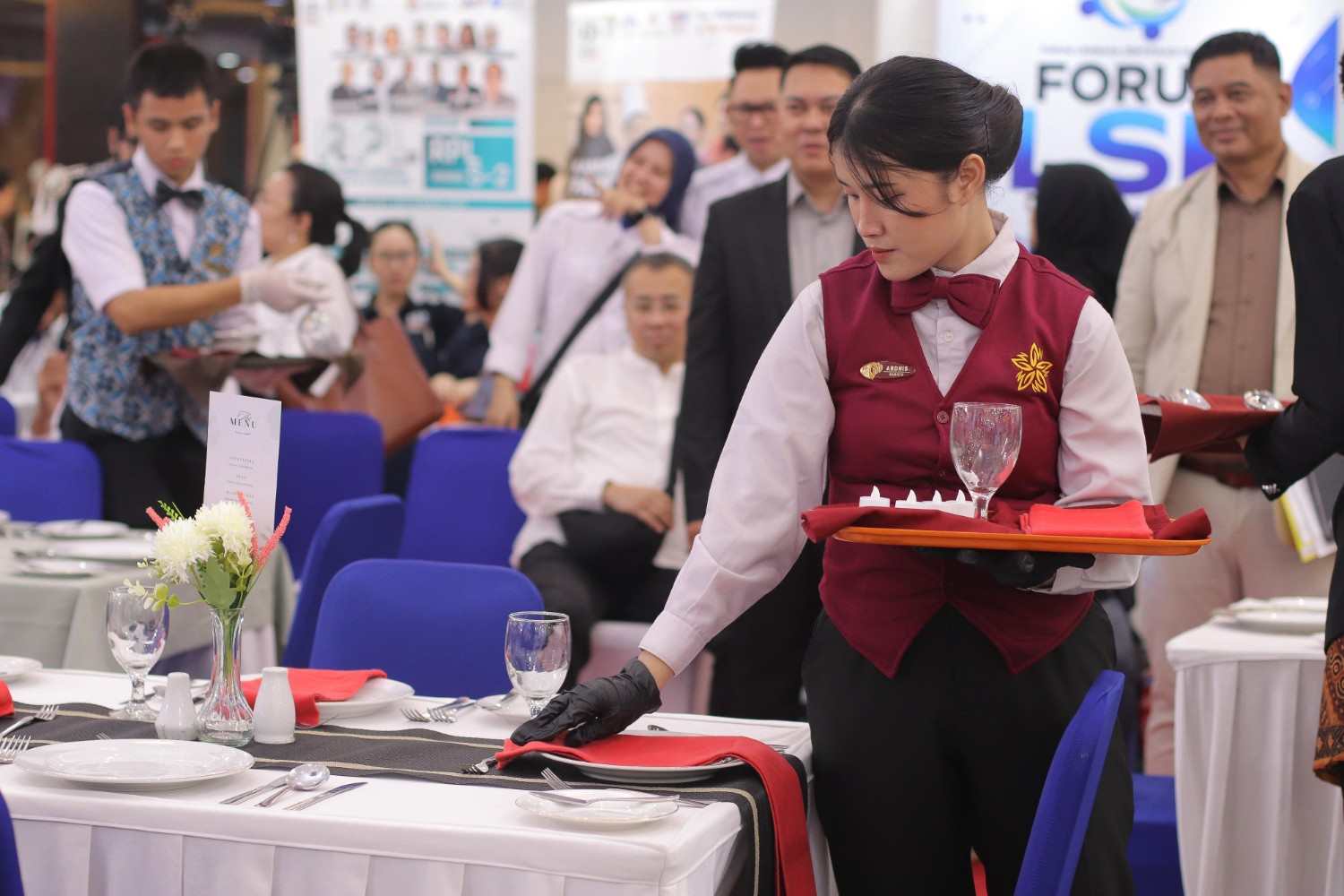 Salah satu peserta fokus menyelaraskan tata letak peralatan makan dalam Lomba Table Set Up Nasional pada rangkaian Gebyar Kursus 2026 di Plaza Festival, Jakarta, Sabtu (29/9/2026). (Foto: Dok. Tim Media Forum PLKP)
