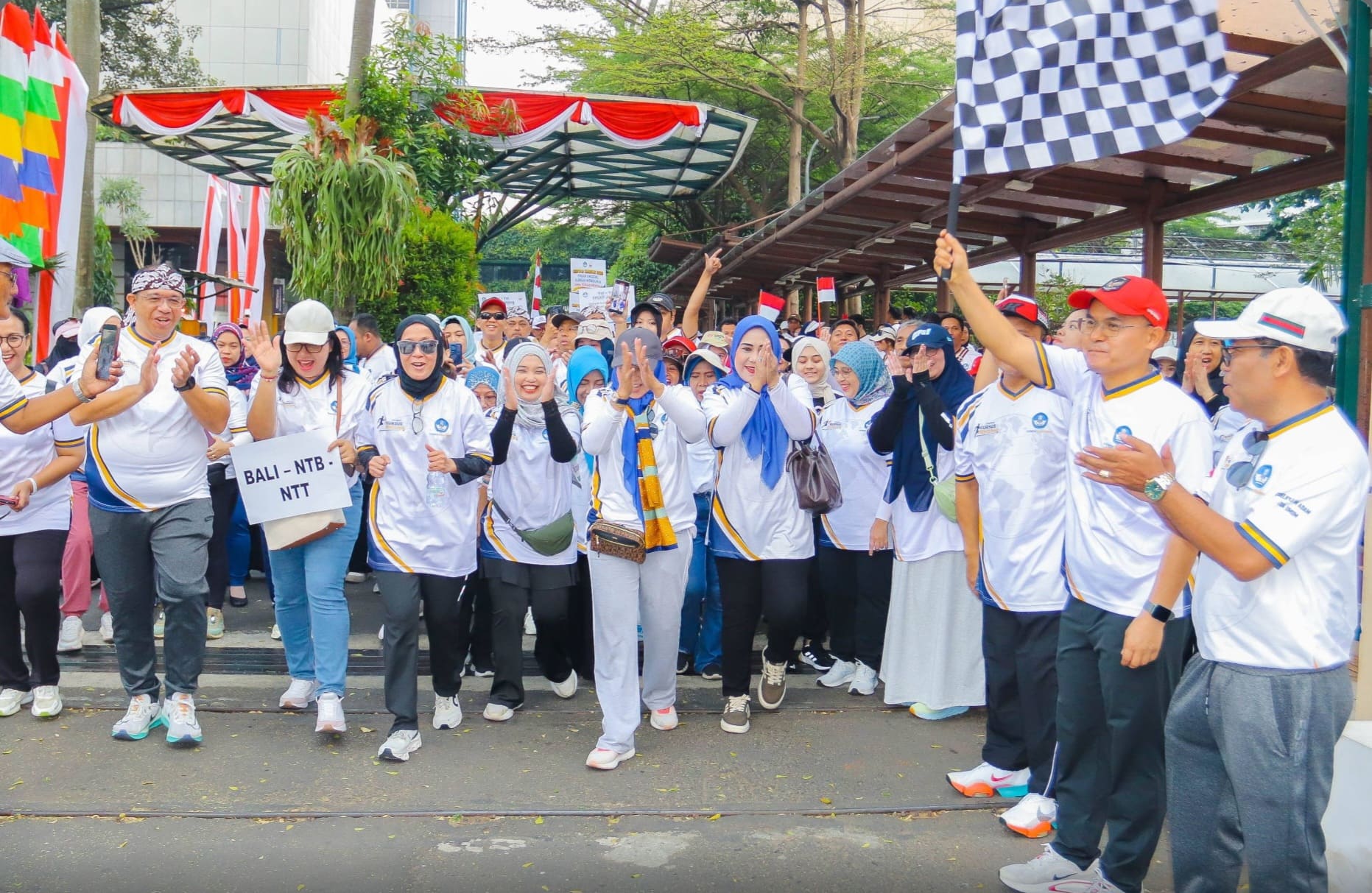 Direktur Jenderal Pendidikan Menengah dan Pendidikan Khusus, Tatang Muttaqin, S.Sos., M.Ed., Ph.D., didampingi Direktur Kursus dan pelatihan Yaya Sutarya, serta Ketua Umum DPP FPLKP Zoelkifli M. Adam, mengibarkan bendera start saat melepas ribuan peserta Jalan Santai Gebyar Kursus 2026 di Komplek Kemendikdasmen, Jakarta, Minggu (30/8/2026). Foto: Dok. Tim Media Forum PLKP