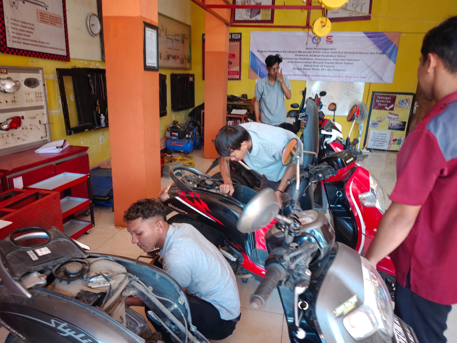 Bukan cuma teori di kelas, para peserta Program PKW Teknik Sepeda Motor di LKP Erlangga Blitar langsung terjun melayani servis motor warga. (Foto. Dok Istimewa/ LKP Erlangga Blitar)